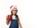 Mischievous funny baby girl in Santa hat, drinking hot cocoa drink and eating marshmallows, isolated on white background