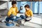 Mischievous little boys creating cacophony by drumming on saucepans