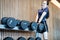 Mischievous teen girl trying to lift large dumbbells on the dumbbell rack in the gym,workout to show lift heavy weights,