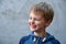 Mischievously laughing schoolboy with blond hair