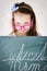 Miserable girl standing behind the blackboard