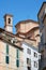 Misericordia church back part in red bricks and old buildings with balcony in a sunny day, blue sky in Mondovi, Italy