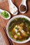 Miso soup in a white bowl and ingredients vertical top view