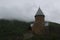 Mist-covered tower of ancient georgian fortress Ananuri