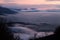 Mist and fog between valley and layers of mountains and hills at dusk, in Umbria Italy, with city lights underneath