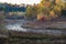 Mist hovers over the creek on an autumn morning