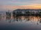 Mist landscape, blurred shapes, reed reflection in water, sunrise on lake