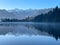 Mist on the scenic Matheson Lake in Fox Glacier with the Southern alps in the background in the West Coast New Zealand