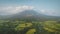 Mist at volcano eruption aerial. Clouds of haze over Mayon mount peak. Tropical green farmland