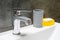 Misted chromed metal faucet for hot and cold water, gray cup for toothbrushes or cotton pads and a yellow soap dish