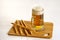 Misted mug of amber clear beer on a wooden board
