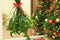 Mistletoe bunch hanging in room with Christmas trees, closeup. Space for text
