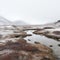 Misty Arctic Tundra: A Serene Snowcovered Valley With A Stream