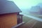 Misty autumn morning. Wooden houses in the fog