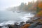 misty autumn shoreline with crashing waves and fishing boats