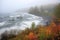 misty autumn shoreline with crashing waves and fishing boats