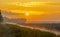 Misty canal in an agricultural field below a blue yellow sky in sunlight at a foggy sunrise in a spring morning