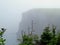 Misty cliffs with hikers on the edge, Skerwink Trail, Newfoundland and Labrador, Canada