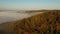 Misty clouds over the autumn forests, aerial.