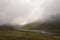 Misty and cloudy scenery in green fertile river valley creating moody scene