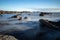 Misty Coastal Waters Flow Around Rocky Foreshore