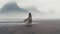 Misty Gothic: A Girl In A Dress Walking On A Beach Surrounded By Mountains