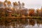 Misty late fall landscape, wild lake in the autumn forest with reflection in the calm water