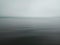 Misty morning background in the sea. Fog over lake wave water. Calm beach view. Tranquil empty nature landscape with gloomy sky.