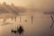 A misty morning by the lake. Small fishing boat at the lake.