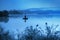 Misty morning, man fishing in lake