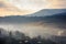 misty morning scene of mountainous rural area with village