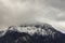 Misty mountain moody landscape scenic view winter lonely peak with slightly snow cover and gray cloudy sky