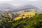 Misty mountain valley with fields and meadows. Scenic picturesque farmland landscape.