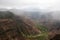 A misty rain falling over Waimea Canyon on a cloudy day in Waimea Canyon State Park, Kauai