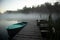 Misty Serenity: Teal Rowing Boat and Wooden Footbridge Embraced by Summer Morning Fog