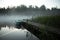 Misty Serenity: Teal Rowing Boat and Wooden Footbridge Embraced by Summer Morning Fog