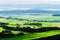 Misty valley of Broumovsko in Czech Republic with fields and green meadows. Vast panorama of Viznov village in the Sudetes.