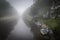 Misty weather in Breda city channel with boats lying calm in the water