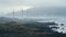 Misty Wind Farm: Nature-inspired Imagery Of A Rocky Shore