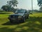 Mitsubishi classic car sedan parked on a green grass field on a sunny day