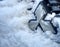 Mitsubishi logo on the radiator grille covered by the snow of the used and slightly dirty Japanese-made vehicle, illustrative