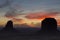 A Mitten Butte and Merrick Butte in silhouette seen at sunrise