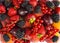 Mix berries and fruits on white background. Ripe blackberries, strawberries, red currants, plums and peaches. Top view. Background
