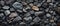 A mix of black rocks and a single brown bedrock for art or building material