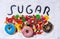 Mix of candies donuts and sugar in writing