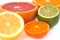 Mix of citrus fruits cut in half in close-up on white background
