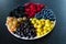 Mix of colored berries in a round plate divided by triangles. Stylish layout of useful vitamins of summer berries