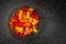 Mix of Colourful  mini bell peppers in glass bowl on dark background, copu space,  top view