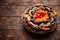 Mix of dried fruits in a small wicker basket on wooden table