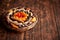 Mix of dried fruits in a small wicker basket on wooden table